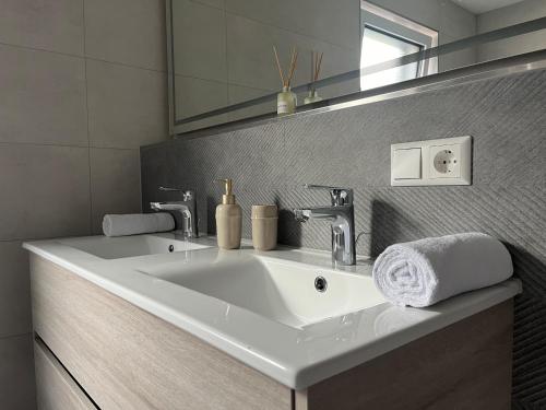 a bathroom with a white sink and a mirror at Schlüssel Apartments in Lahr