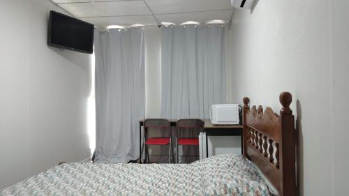 a bedroom with a bed and a desk with two chairs at Albergue Cultural Hostel in Rio de Janeiro