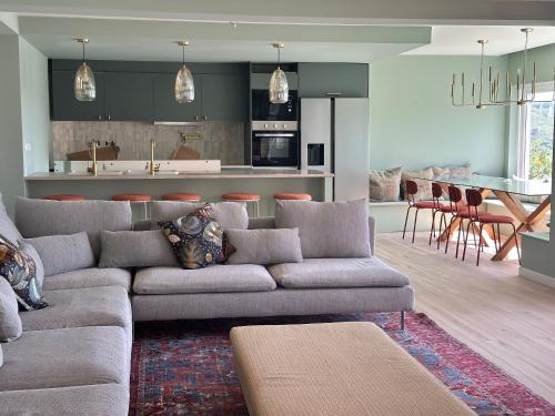 a living room with a couch and a kitchen at Retreat Villa, 17m to Downtown, up to 29ppl in Lisbon