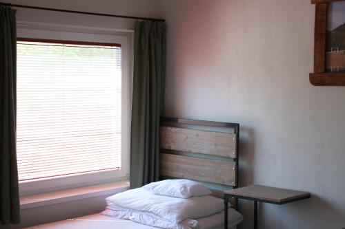 a bedroom with a bed and a window at Zamárdi Trafóház in Zamárdi