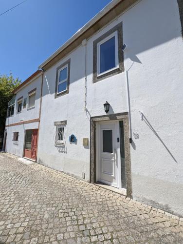 a white building with a door on the side of it at Torre de Santiago - Guest House in Vila Praia de Âncora