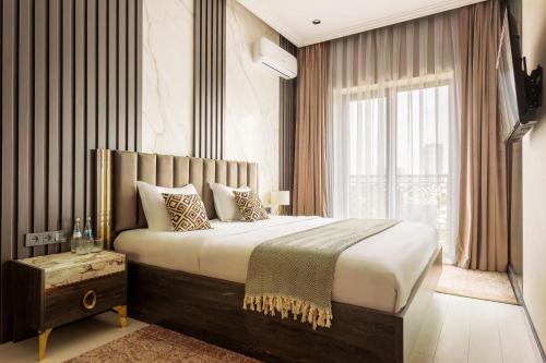 Un dormitorio con una cama grande y una ventana en 107 LUXURY APARTMENT in AC KAZAKHSTAN, Minor area, Amir Timur Avenue, en Tashkent