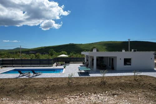 a villa with a swimming pool and a house at Kuća za odmor 'Luca' in Ljubuški