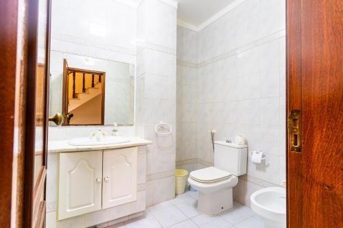 a bathroom with a toilet and a sink and a mirror at Beach House Villa At Peniche - Praia Consolação in Atouguia da Baleia