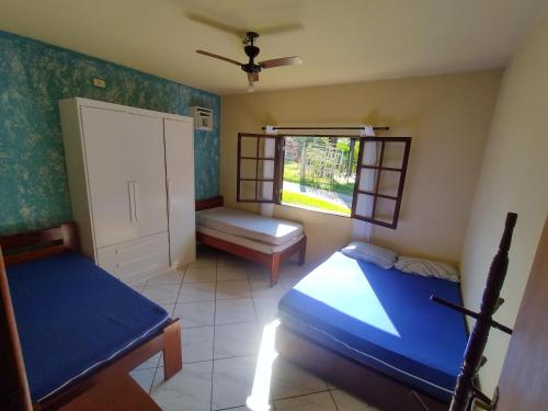 a bedroom with two beds and a window at CASA PRUMIRIM in Ubatuba