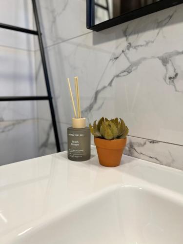 a bathroom sink with a candle and a potted plant at Villa Diomedes in Sani Beach