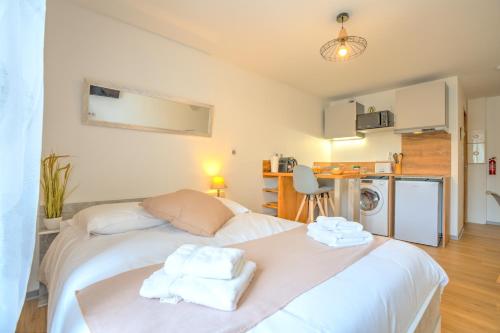 une chambre avec un lit avec des serviettes dessus dans l'établissement Le Déroc - Netflix Wi-Fi Fibre Terrasse, à Banassac