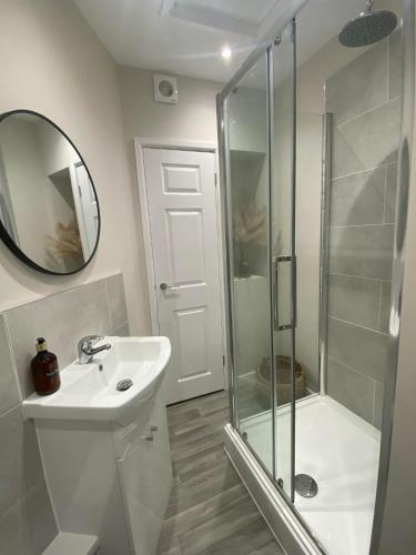 a bathroom with a shower and a sink and a mirror at The Retreats 2 Kenfig Hill Pet Friendly 2 Bedroom Flat with King Size bed twin beds and sofa bed sleeps up to 5 people in Kenfig Hill