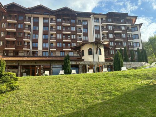 a large building with a lawn in front of it at Panorama Resort Bansko Wellness & Recreation in Bansko