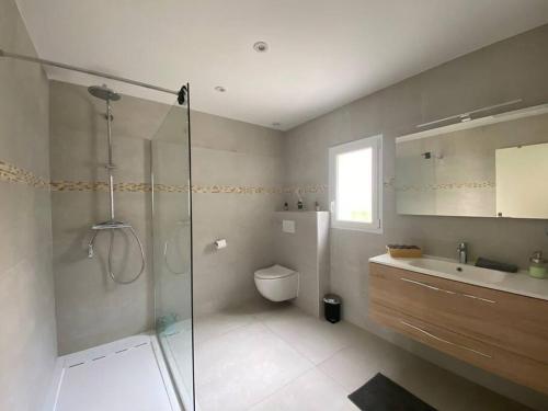 une salle de bain avec une douche, des toilettes et un lavabo dans l'établissement Maison moderne plain pied, à Saussan