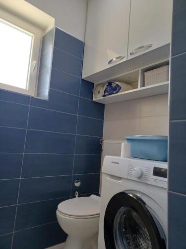 a bathroom with a toilet and a washing machine at Studio apartman Marija in Trogir