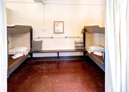 a room with three bunk beds and a wooden floor at HI Vancouver Jericho Beach - Hostel in Vancouver