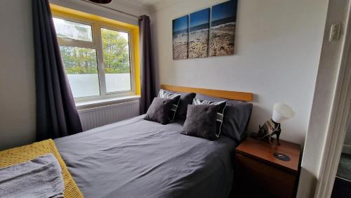 a bedroom with a bed with pillows and a window at 3 Bed House, Stunning Views And Free Parking in Rottingdean