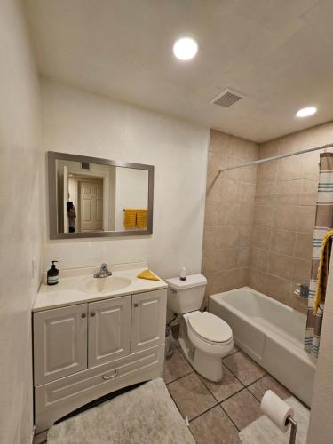 a bathroom with a sink and a toilet and a tub at Chandler Charming Home in Chandler