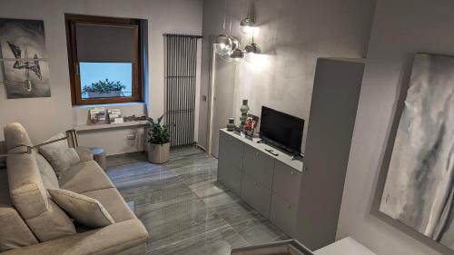 a living room with a couch and a television at LA VIA DEL SALE accommodations holidays in Domodossola