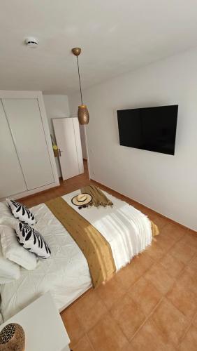 a bedroom with a bed with a tv on the wall at Amarillo Costa Calma Sun in Costa Calma