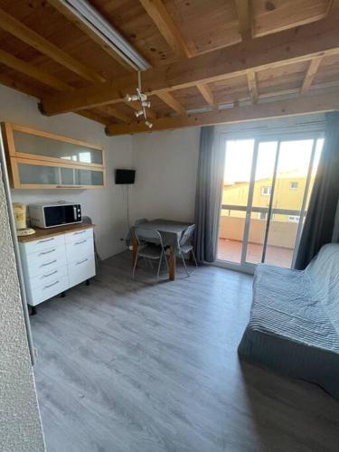 une chambre avec un lit et un bureau avec un micro-ondes dans l'établissement Apt 6 personnes plus 2 enfants 200m de la plage ,Draps et serviettes non fournies, au Cap d'Agde