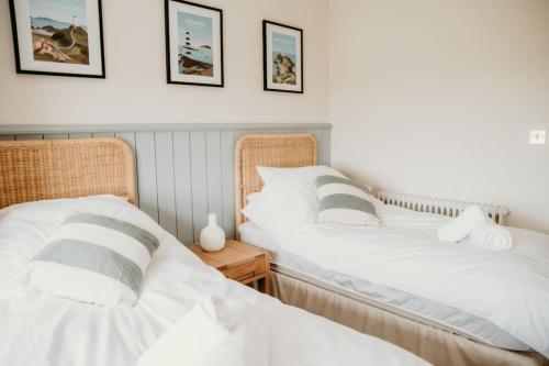 two beds sitting next to each other in a bedroom at Morlun, Trearddur Bay, Isle of Anglesey in Trearddur