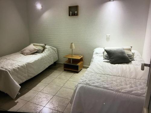 une chambre avec deux lits et une table avec une lampe dans l'établissement Vacances paisibles, à Alata