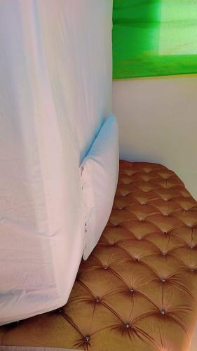 - un lit avec un drap blanc au-dessus dans l'établissement HOTEL LA BARRICA, à SJM