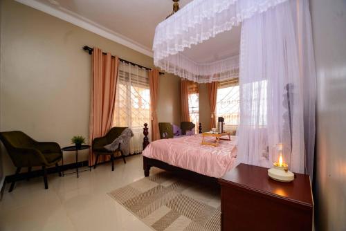 a bedroom with a bed with a pink bedspread at PNG Guest house Kitende in Kampala