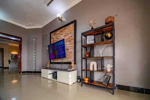 a living room with a shelf and a wall at PNG Guest house Kitende in Kampala