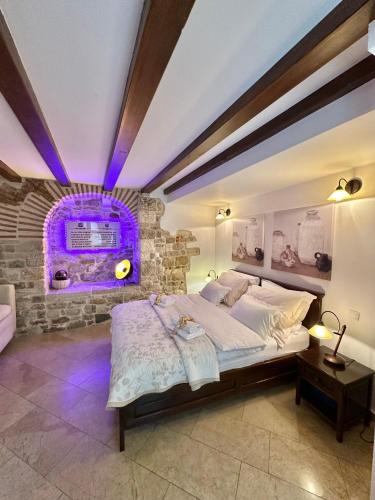 スプリトにあるDiocletian Wine studio apartmentのベッドルーム1室(紫色の照明が付いた大型ベッド1台付)