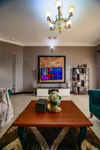 a living room with a coffee table and a flat screen tv at PNG Guest house Kitende in Kampala