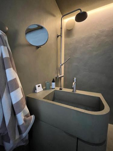 La salle de bains est pourvue d'un lavabo et d'un miroir. dans l'établissement Groenendijk 8, à Oostduinkerke