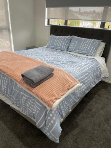 a bed with blue and orange sheets and pillows at 11 A Addison street home stay - room 2 in Auckland