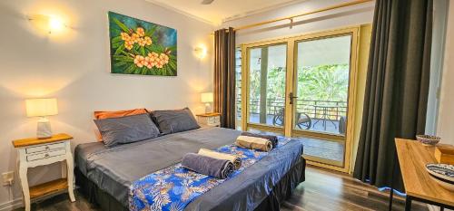 ein Schlafzimmer mit einem Bett und einem Balkon in der Unterkunft Tipani Lodge - Free and Unlimited Wifi in Rarotonga