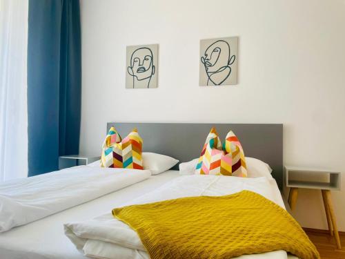 a bedroom with two beds and two paintings on the wall at APSTAY City Center I FREE Parking I Self Check-in in Graz