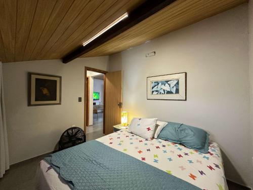ein Schlafzimmer mit einem Bett und einer Holzdecke in der Unterkunft Arara Azul in Florianópolis