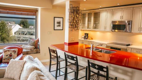 a kitchen with a red counter top and a living room at Carleton Lodge in Whistler