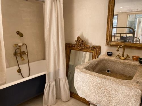 a bathroom with a sink and a tub and a mirror at LOFT AUTHENTIQUE 3 STARS Terrasse VIEUX PORT in La Ciotat