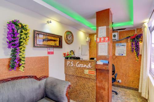 a room with a reception desk and flowers on the wall at Hotel O P S Grand in Port Blair