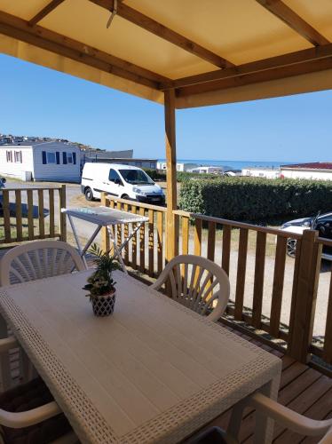 une table et des chaises en bois sur une terrasse dans l'établissement CHEZ ISA - Mobil home 3 chambres, à Le Portel