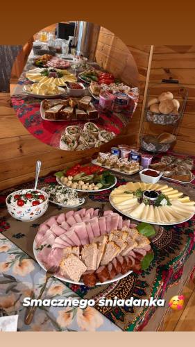 un tavolo pieno di diversi tipi di cibo su piatti di Pokoje przy Parkowej a Zwierzyniec