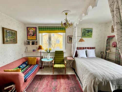 a bedroom with a bed and a table and a couch at LITTLE LONDON boutique apartment with Netflix, top location in Old Town in Narva
