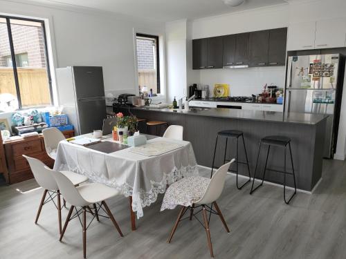 a kitchen with a table and chairs in a kitchen at Queen Bed Guest Room in Brand New House in Leppington