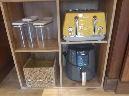 a cupboard with a coffee maker and a mixer in it at Willow Cottage Accommodation in Sligo
