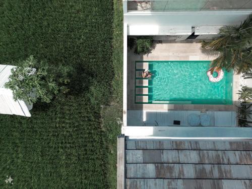 een uitzicht over een zwembad met twee personen bij Villa Linns in Kerobokan