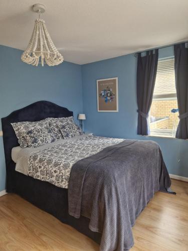 a bedroom with a bed with blue walls at B&B Le Bon Vivant Eindhoven in Eindhoven