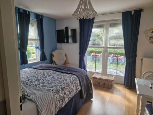 a bedroom with a bed with blue walls and windows at B&B Le Bon Vivant Eindhoven in Eindhoven