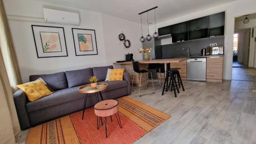 un salon avec un canapé et une cuisine dans l'établissement Un second souffle, à Foix