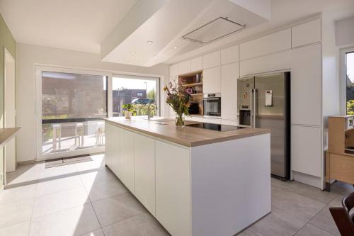 a large kitchen with white cabinets and a counter top at Lichtrijke woning vlakbij Leuven in Herent