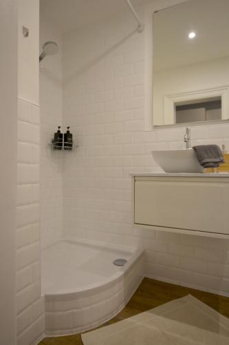a white bathroom with a tub and a sink at MeetsLeopold in Vienna