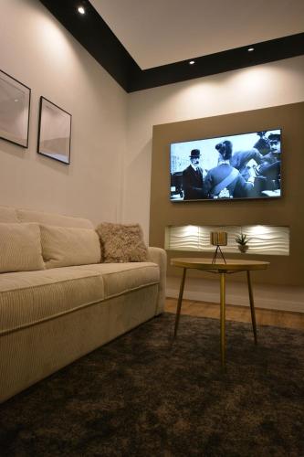 a living room with a couch and a flat screen tv at MeetsLeopold in Vienna
