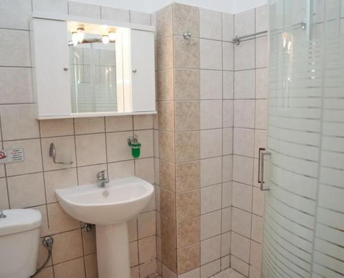La salle de bains est pourvue d'un lavabo, de toilettes et d'un miroir. dans l'établissement Villa Mare Ammoudia, à Ammoudia