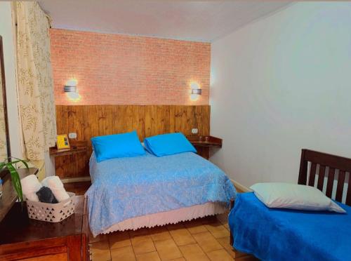 a bedroom with a bed with blue pillows at Pousada e Restaurante Dona Siroba in Morretes